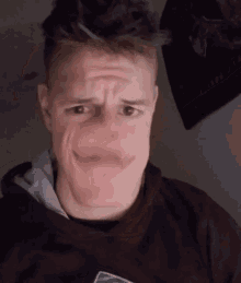 a man making a funny face while wearing a black shirt