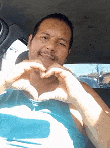 a man making a heart shape with his hands