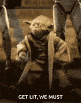 yoda from star wars is sitting on the ground with a sword in his hand and the words `` get lit , we must '' .
