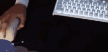 a person is holding their hands together in front of a keyboard and mouse .
