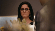 a woman wearing glasses is looking at a man