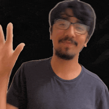 a man wearing glasses and a blue shirt is waving his hand