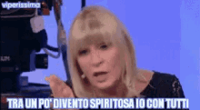 a woman is talking to a camera with the words tra un po ' divento spiritosa io con tutti below her