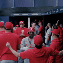 a phillies baseball player is surrounded by his team