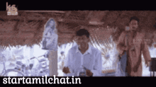 a man standing under a thatched roof with the website starttamilchat.in visible
