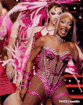 a woman in a pink and silver outfit is dancing on stage