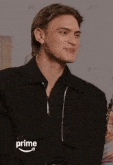 a man in a black jacket with the word prime on the bottom right