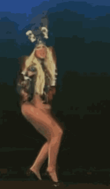 a woman wearing a hat with skulls on it is dancing on a stage