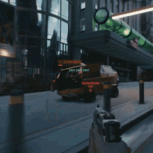 a person holding a gun in front of a vehicle with scavengers written on it