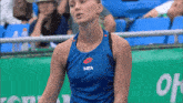 a woman wearing a blue tank top with mta on it