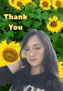 a woman wearing glasses stands in front of a field of sunflowers with the words thank you written above her