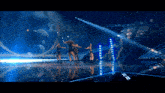 a group of women are dancing on a stage with a blue background