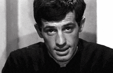 a black and white photo of a man 's face looking at the camera