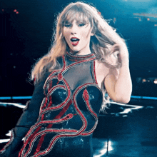 a woman wearing a black and red dress with a snake design on it