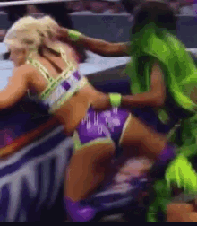 a woman in purple shorts and a green vest is wrestling a man in a green vest .