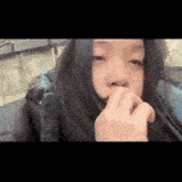 a woman is covering her mouth with her hand .