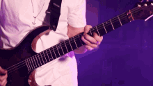 a man in a white shirt is playing a guitar with a strap that says ' fender ' on it