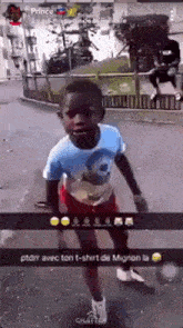 a young boy is playing with a soccer ball on the street .