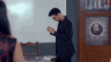 a man in a suit is standing in front of a poster that says ' king ' on it