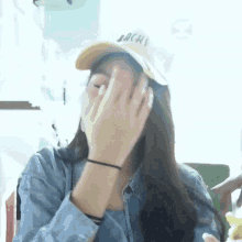 a woman wearing a hat that says lachs covering her face
