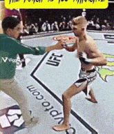 a man in a green shirt is standing next to a man in shorts with ufc written on the ground