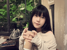 a girl is holding a cup that says ' a ' on it