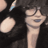 a close up of a woman wearing glasses and blue lip gloss