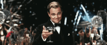 a man in a tuxedo is toasting with a glass of champagne .