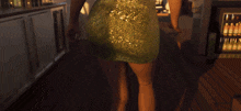 a woman in a green dress stands in front of a refrigerator