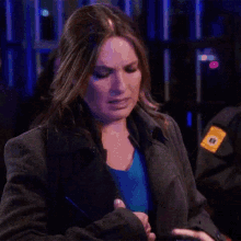 a woman in a gray jacket has a badge on her sleeve that says ' n.y.p.d. '
