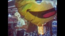 a man wearing a mask stands in front of a yellow balloon