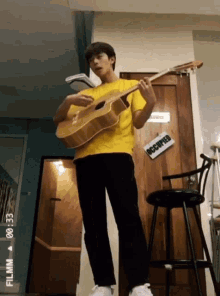 a man playing a guitar in front of a door that has the word occupied on it