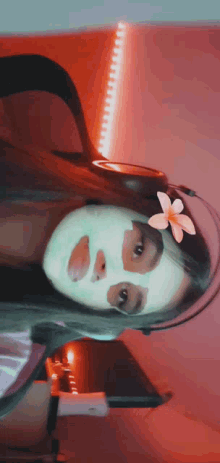 a woman with a flower in her hair is wearing a face mask