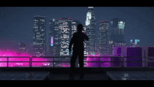 a person standing on a balcony looking at a city skyline at night