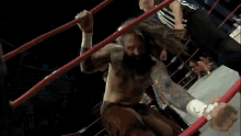 a man in a wrestling ring with a referee behind him