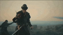 a man in a hat is holding a sword in front of him