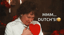 a woman is holding a red heart with the words mmmm dutch 's written above her