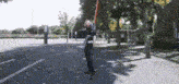 a man in a superhero costume is holding a sword in his hand .