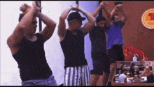 a group of men are dancing in front of a sign that says ' mcdonald 's ' on it