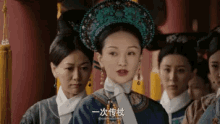 a group of women are standing next to each other and one of them is wearing a turquoise headdress .