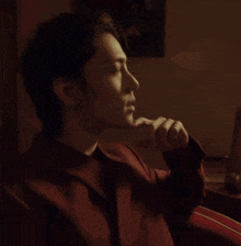 a close up of a person 's face with a hand on their chin