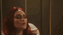a woman with red hair wearing a white dress