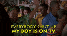 a woman in a green and yellow shirt says everybody shut up my boy is on tv in yellow letters