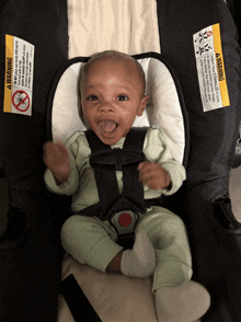 a baby is sitting in a car seat with a warning label