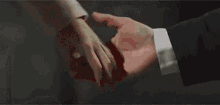 a man and a woman are holding hands in a blurry photo .