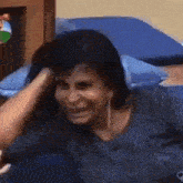a woman is laying on a bed with her hand on her head and making a funny face .