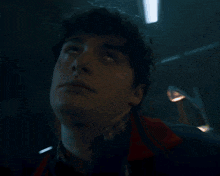 a close up of a man 's face with a red jacket on