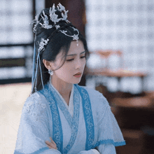 a woman wearing a blue and white dress and a crown on her head
