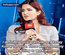 a woman is talking into a microphone and saying `` i definitely have gratitude to akshay kumar for sure .