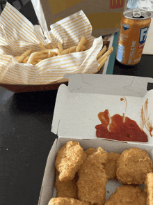 a can of fanta sits next to a box of nuggets